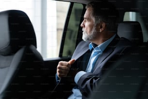 transport, business trip and people concept - senior businessman driving on car back seat