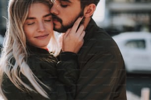 Close up portrait of charming young woman with closed eyes sharing tender moment with her boyfriend