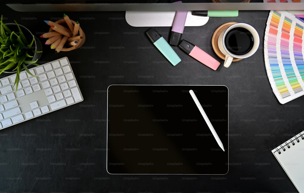 Espace de travail élégant avec tablette graphique numérique, fournitures créatives sur un poste de travail en cuir foncé