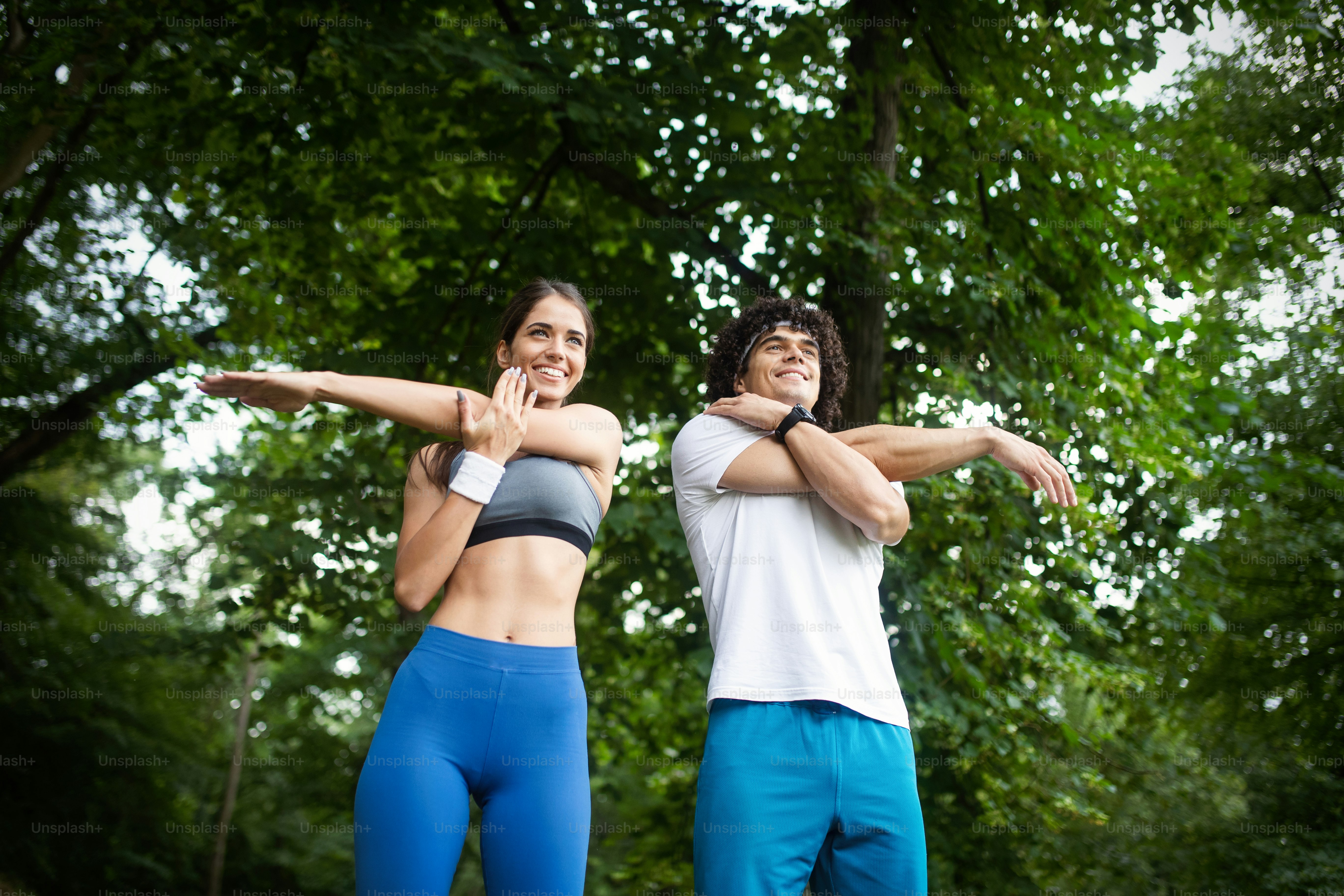Happy couple running and jogging together in nature