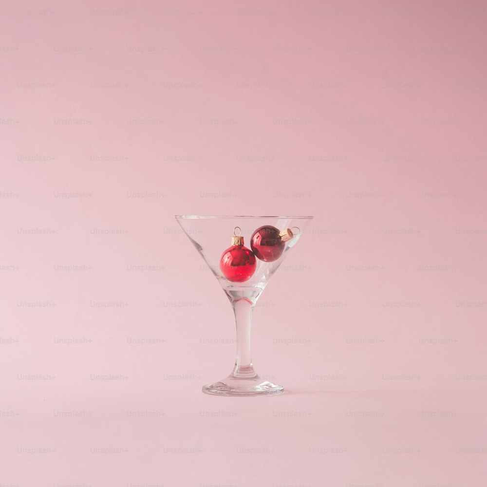 Decorazione dell'albero di Natale in bicchiere martini su sfondo rosa pastello con spazio di copia creativa.