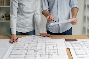 Partners partnership teamwork concept. Cropped collaboration two colleagues person in formal wear shirt stand at the table in bright loft interior workplace look at blank expertise inspect property