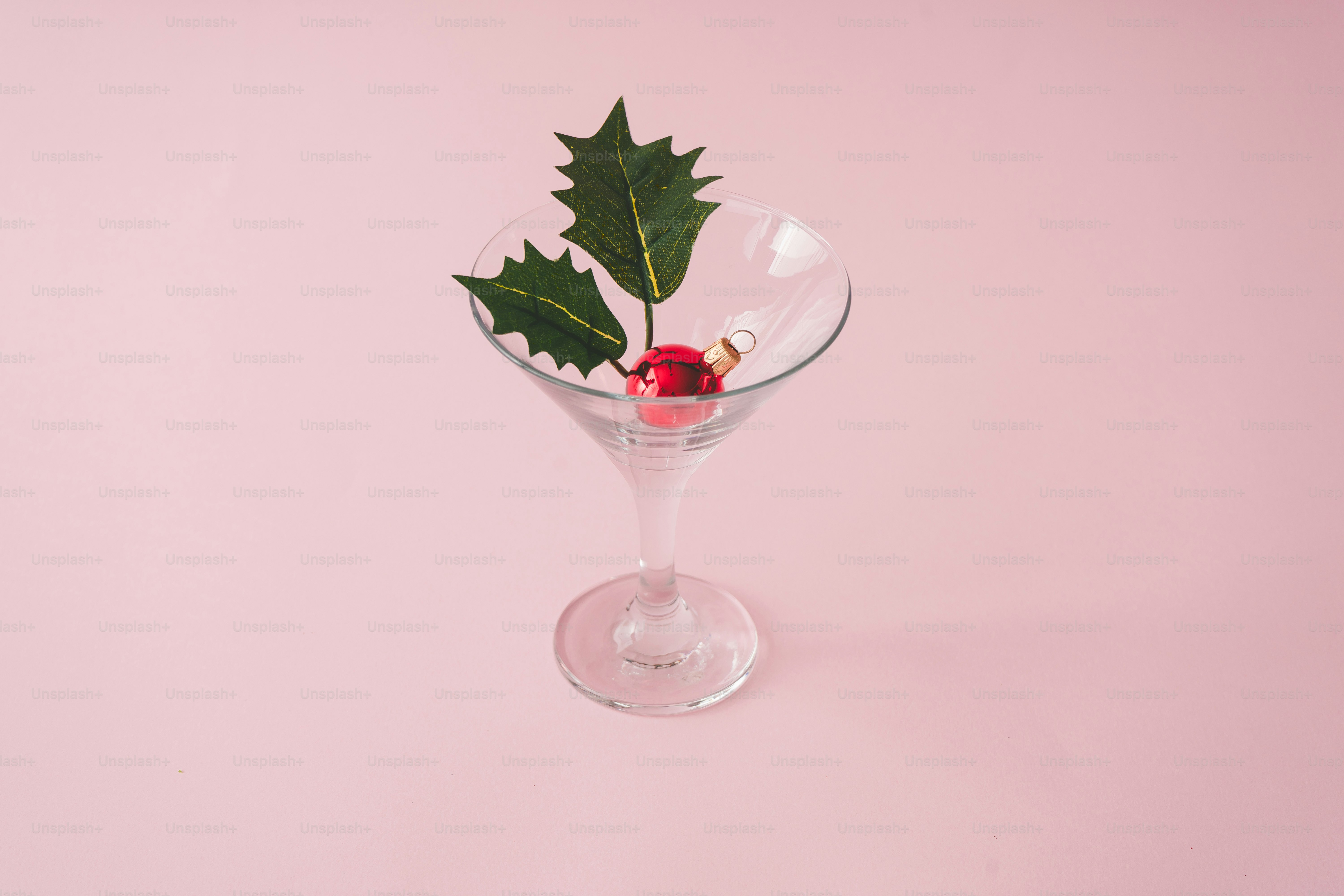 Christmas tree decoration in martini glass on pastel pink background with creative copy space.