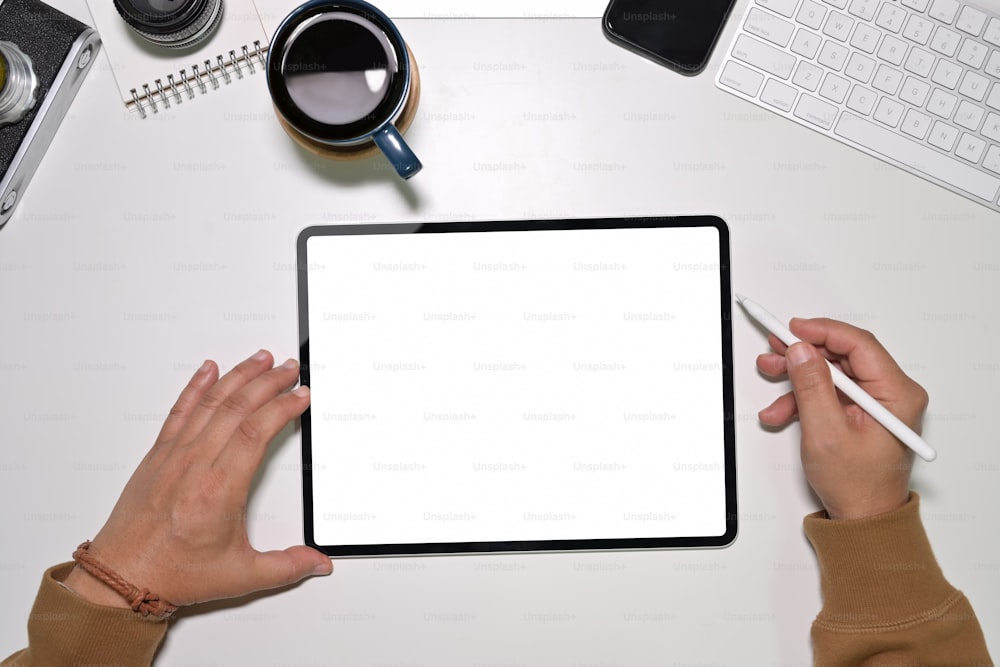 Vista superior del trabajador joven que usa en una tableta moderna con pantalla táctil