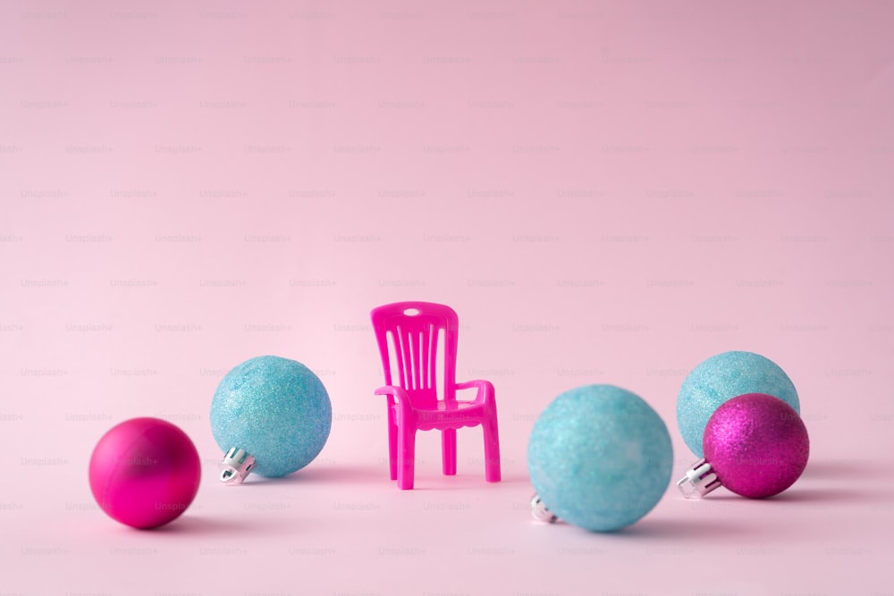 Pink chair in pink room with big Christmas bauble decoration.