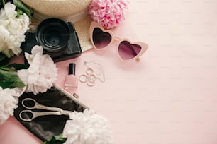 분홍색 모란, 사진 카메라, 복고풍 선글라스, 보석, 매니큐어, 모자, 복사 공간이 있는 파스텔 핑크 종이에 지갑이 있는 세련된 여성스러운 플랫. 세계 여성의 날. 안녕하세요 봄