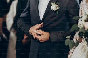교회에서 결혼 반지를 끼고 있는 결혼식 커플. 세련된 신부와 신랑이 키스하고 반지를 교환합니다. 감정적 인 순간, 텍스트를위한 공간. 종교 개념