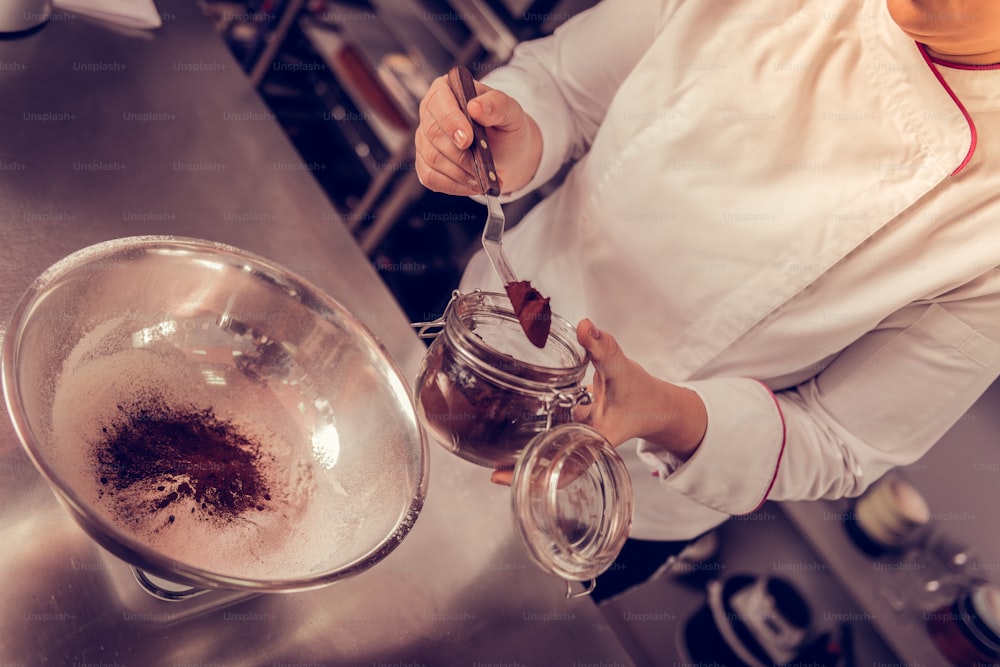 Cake ingredients. Top view of cocoa being added to the flour during the cake preparation process