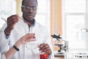 Un travailleur afro-américain travaille dans un laboratoire pour mener des expériences