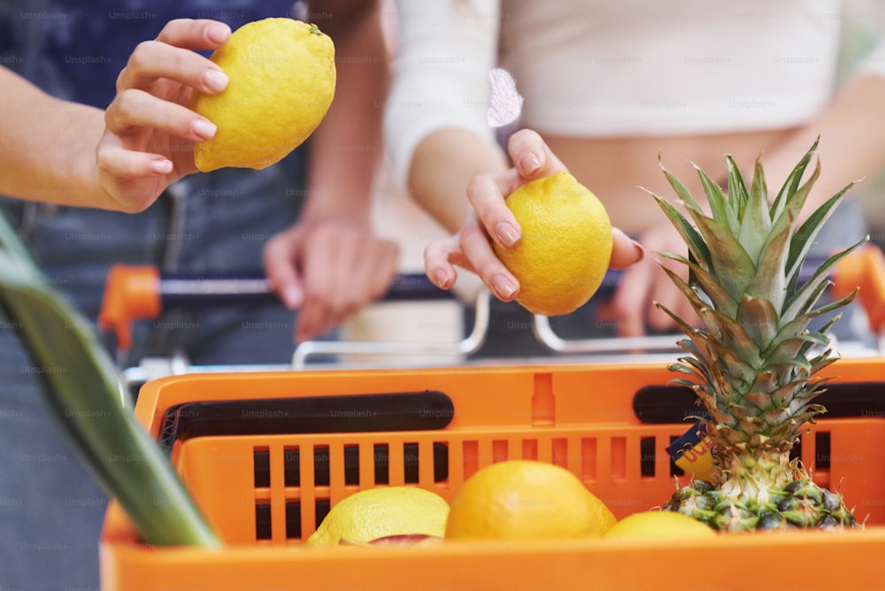 Duas mulheres que escolhem bioprodutos produzem em um supermercado com frutas da lista de compras