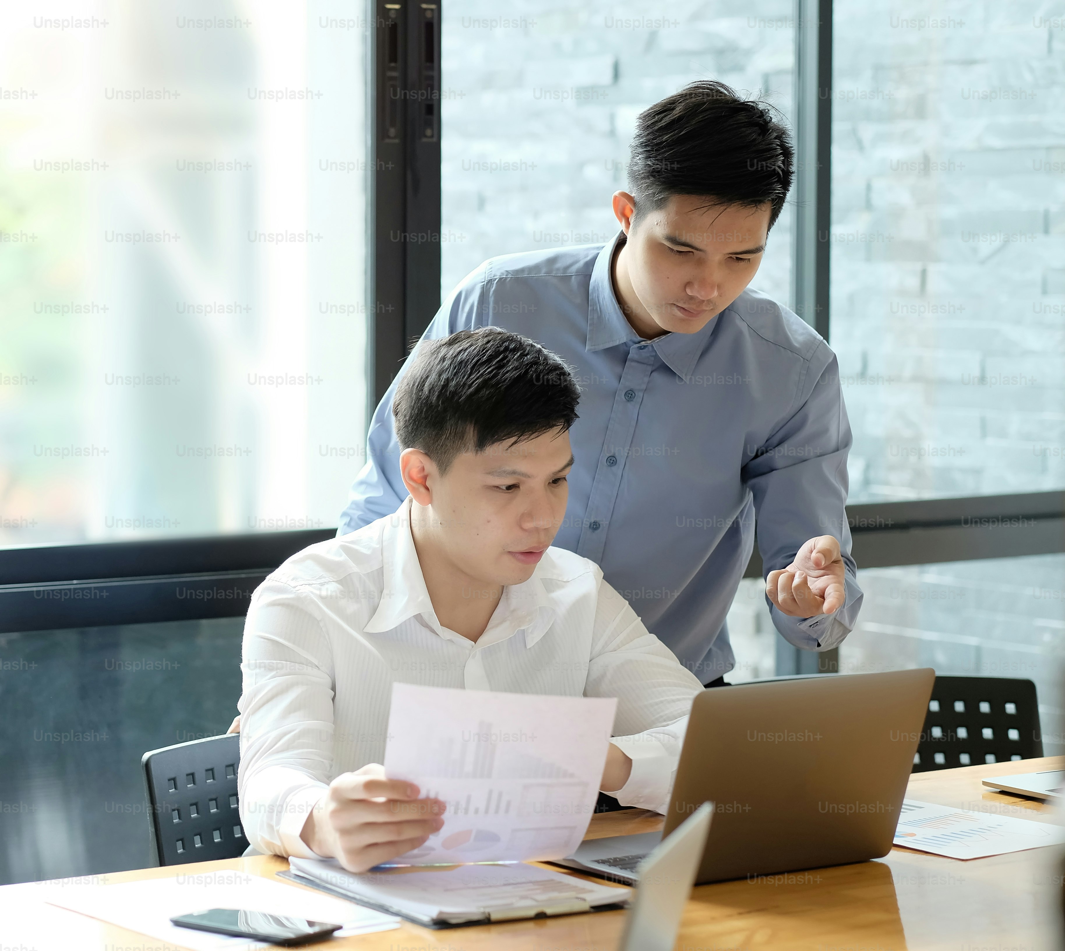 Business partner talking and consult with laptop computer and paper document