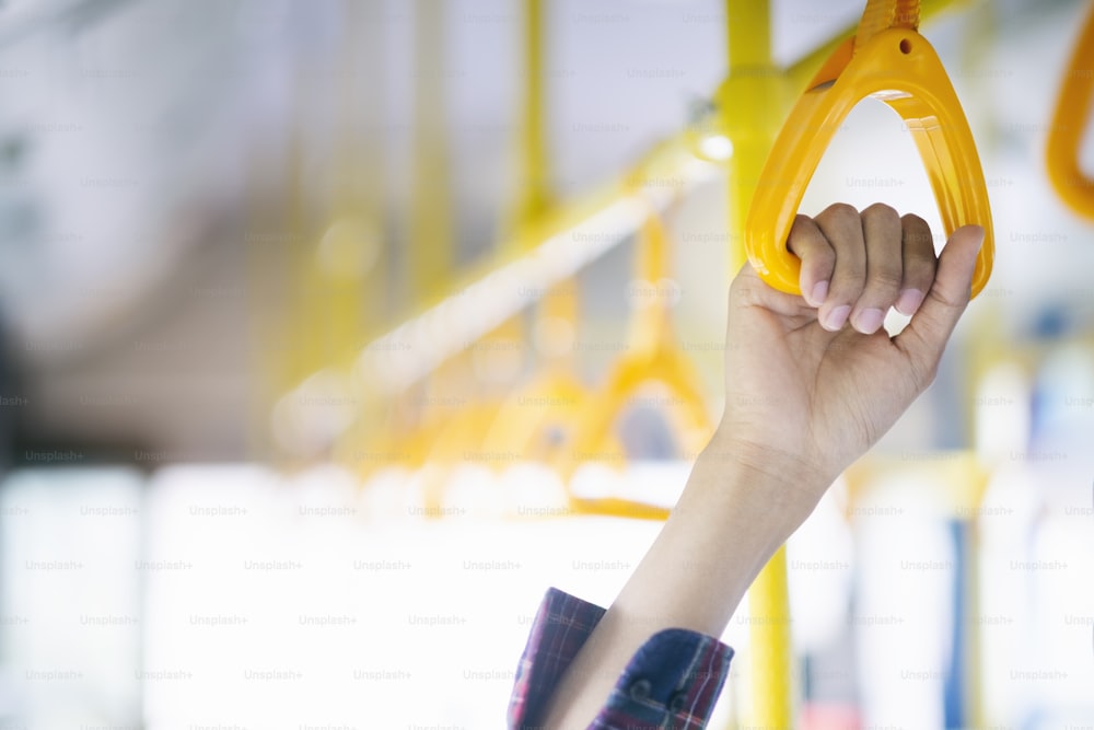 Closeup passenger  hand holding handle on the public transportation.