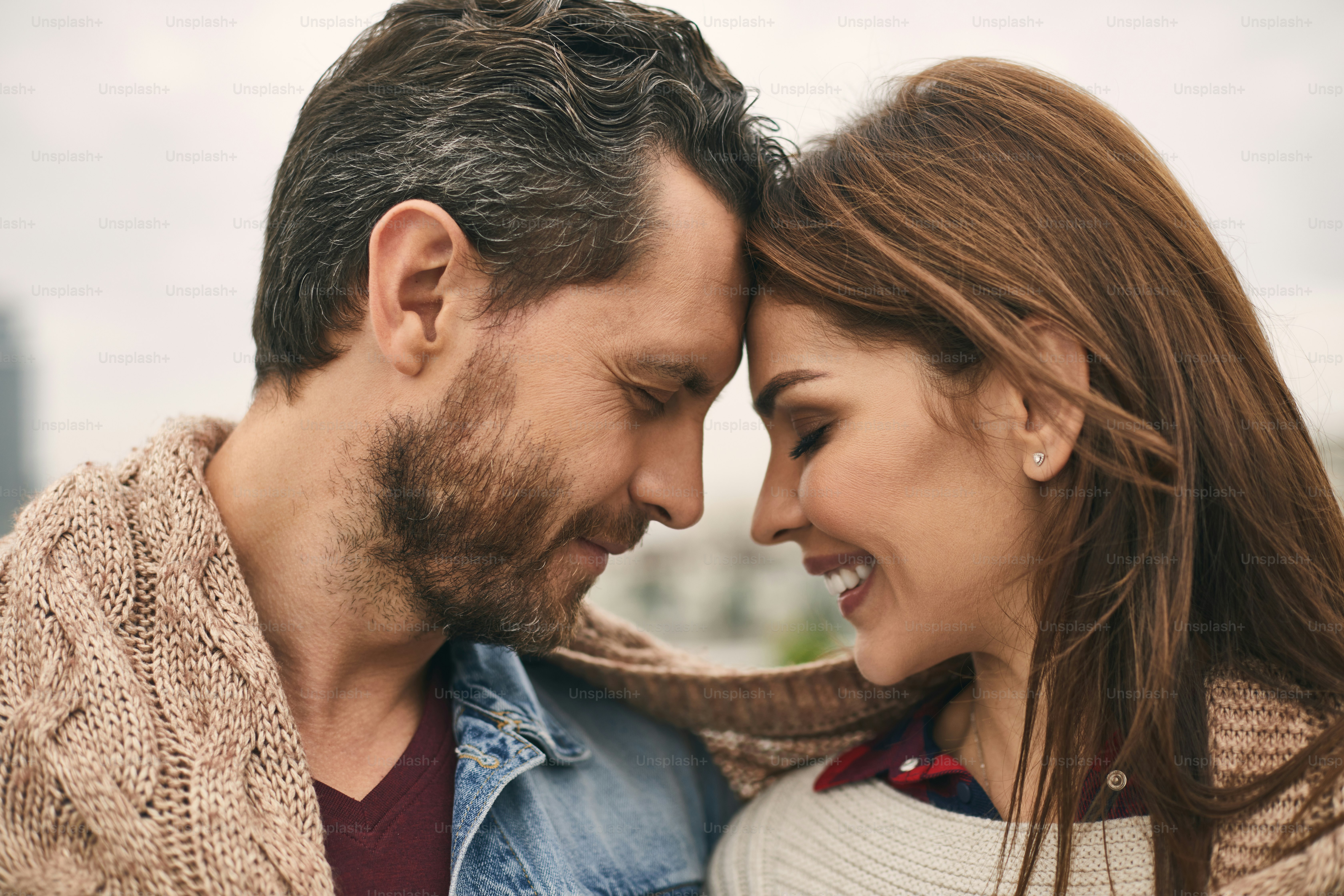 Close up of happy male and female with plaid spending time outdoor and smiling