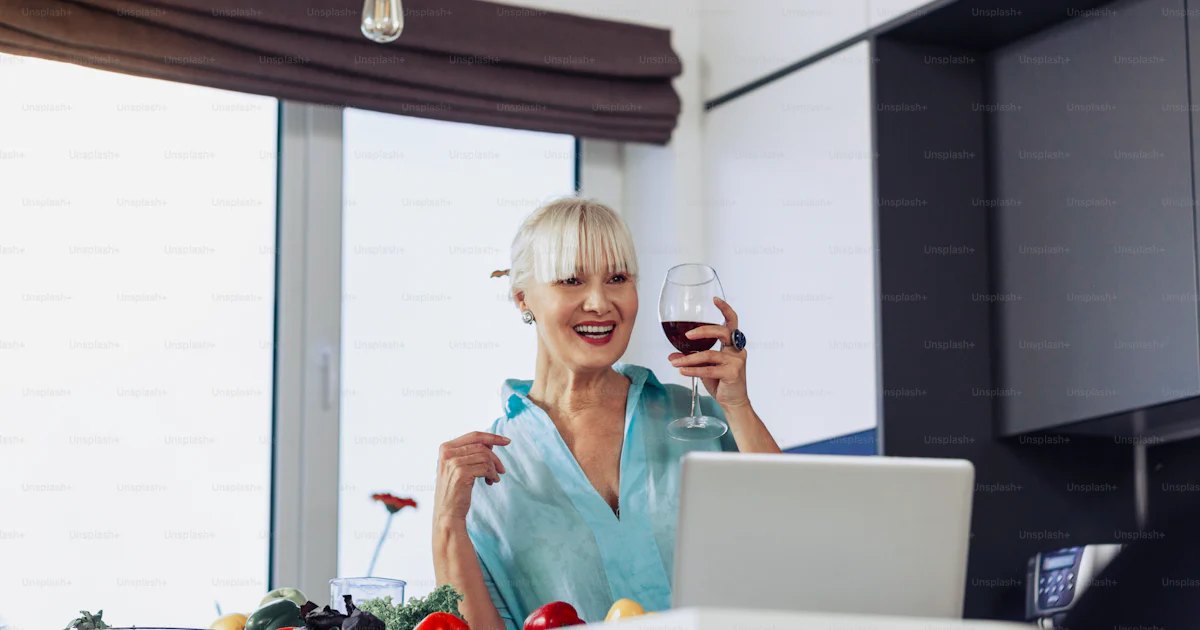 Très bon moment. Femme positive ravie buvant du vin tout en ayant une ...