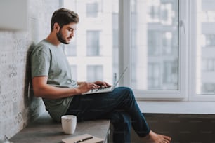 Nice young man restign at home while surfing the Internet