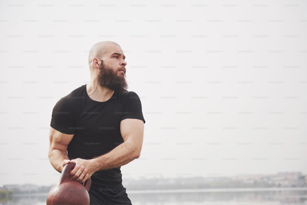 The bearded young man is engaged in outdoor sports.