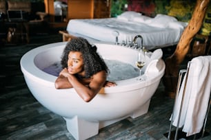 Happy black young woman relaxing in the hot tub