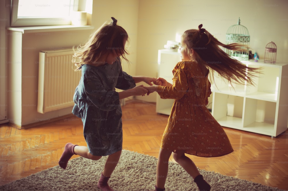 Carefree childhood days. Two little girls playing at home.