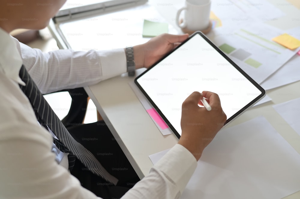 Businessman working with mockup tablet and digital pen on empty monitor tablet.