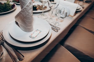 cadre de mariage élégant. Set de table avec invitation, assiette, couverts, verres et serviette de table pour une réception de mariage de luxe. bouquet rustique. espace pour le texte. Restauration coûteuse