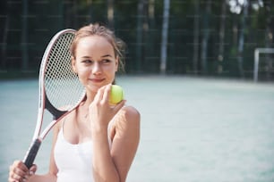 Cute girl playing tennis and posing for the camera