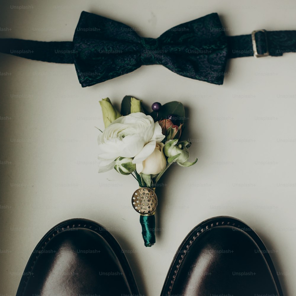 Elegante pajarita de boda con ramo de flores moderno y zapatos sobre fondo de madera vista superior. Preparación rústica de la mañana de la boda. conjunto de novio. Espacio para el texto