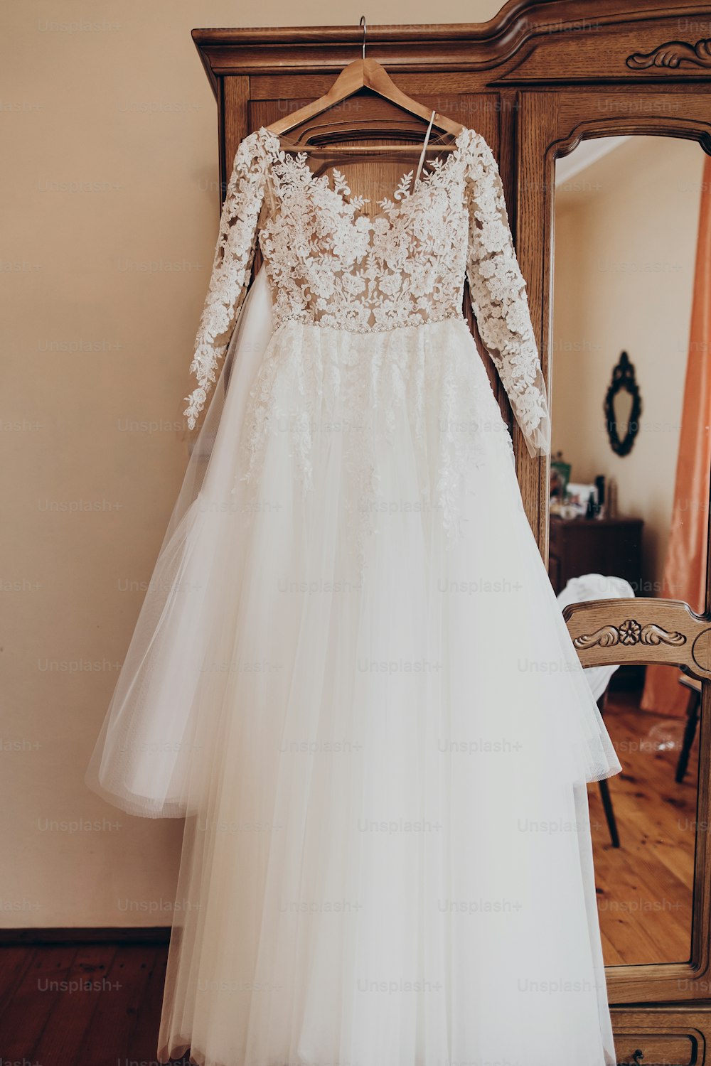 luxury wedding dress on hanger at wooden closet in rustic room. space for text. wedding morning preparation,getting ready. stylish gown