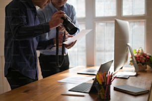 Photographer Colleagues discussing photographs at creative office, Photo editor job.