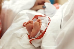 Bautismo bebé. Pequeños pies lindos de una niña en el bautizo en la iglesia