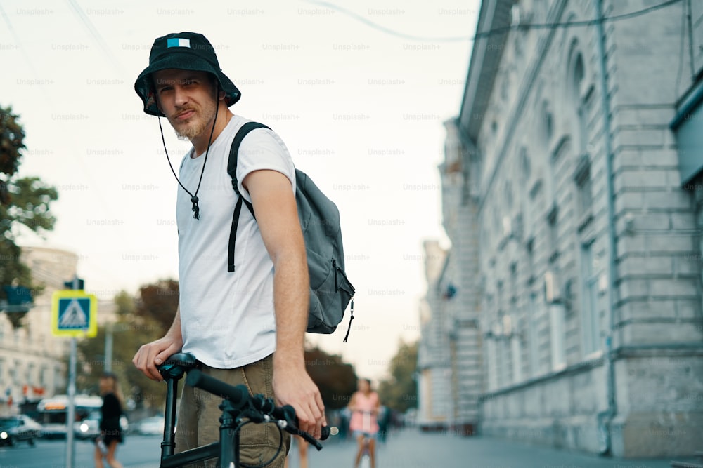 ヨーロッパの古都を屋外で自転車で走る男。ライフスタイル、エコロジカルな輸送、人々のコンセプト。