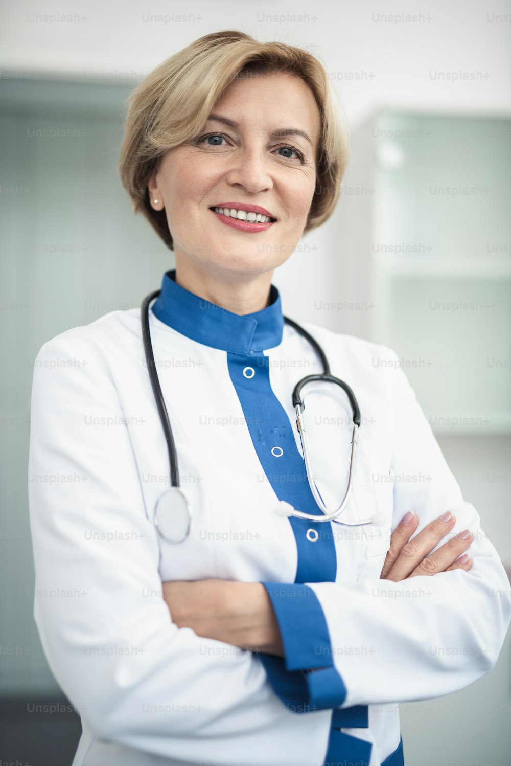 Concept of professional inspiration in healthcare system. Waist up portrait of smiling female doctor in medical uniform confidently standing in cabinet crossing her arms