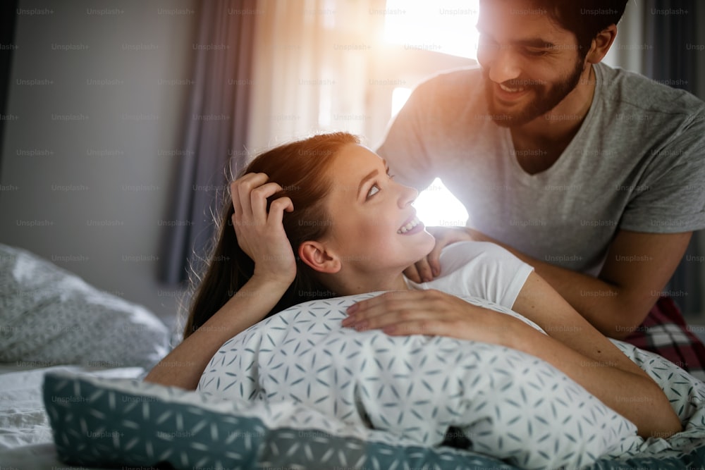 Couple et beaux moments dans le lit - Gros plan d’un petit ami donnant un massage à sa belle petite amie se relaxant dans un lit