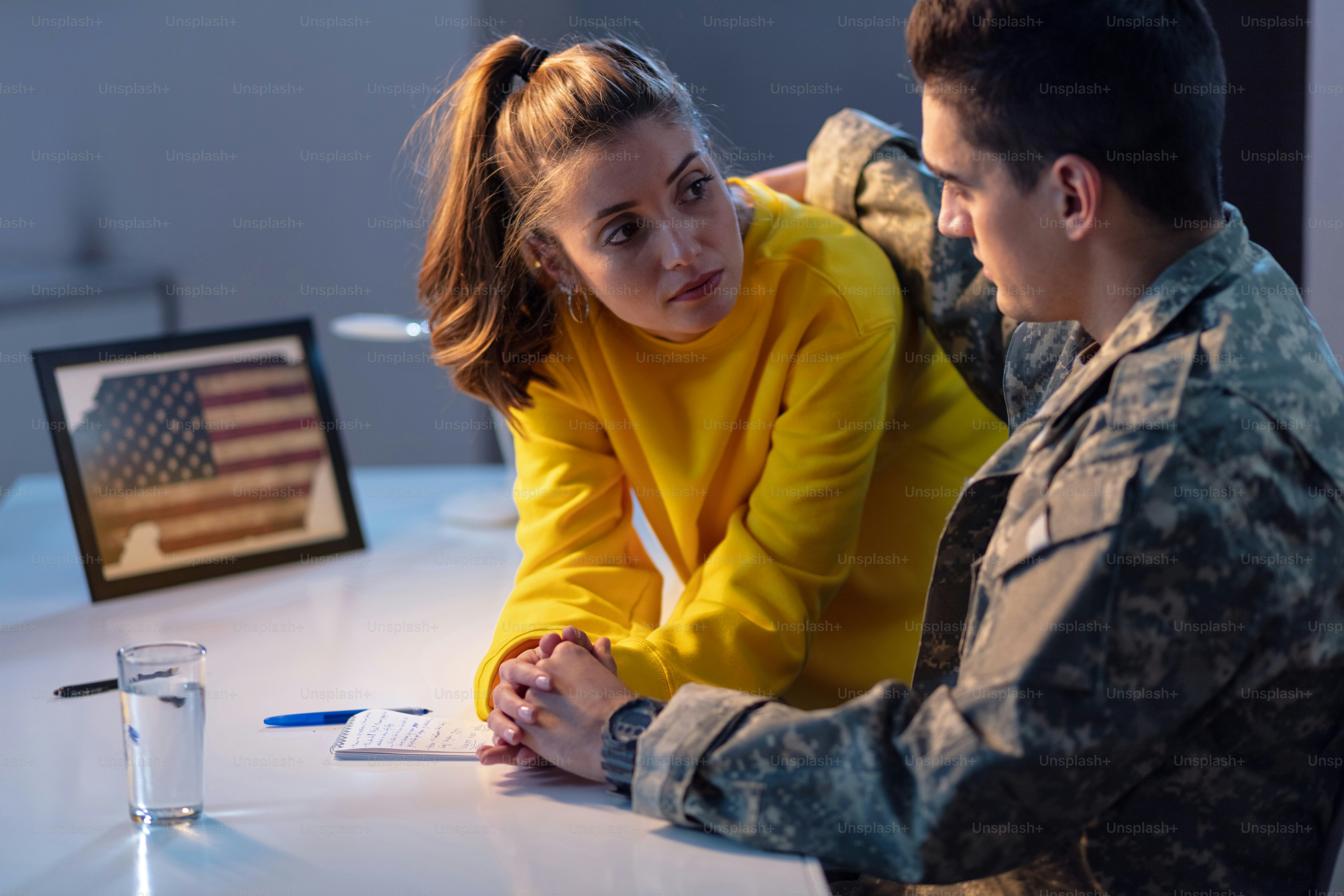 Young woman holding hands and talking to her military boyfriend who is about to go to war.