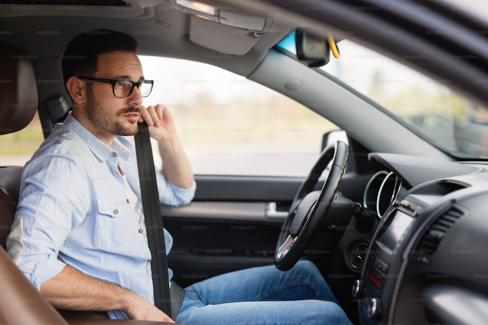 Handsome smart businessman driving a car to work