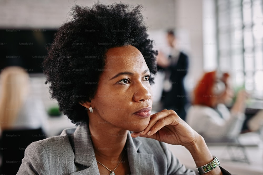 Nahaufnahme Porträt einer schwarzen Geschäftsfrau, die während der Arbeit an etwas denkt.