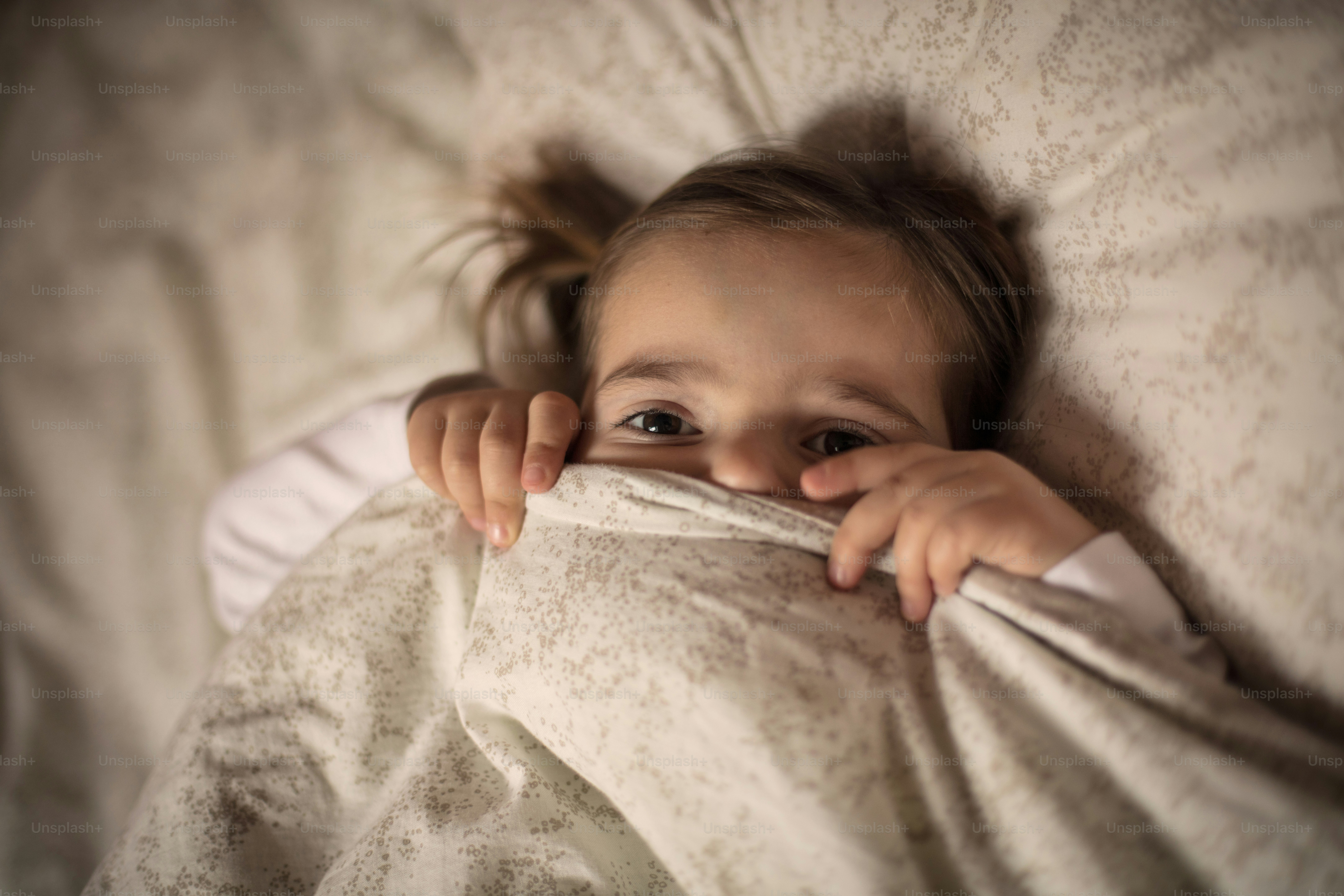 Time for wake up. Little girl in bed.