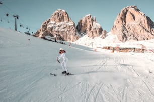 Journée d’hiver blanche comme neige en haute montagne. Femme en veste à la mode avec fourrure, lunettes de ski et casque. Fille qui fait du ski.