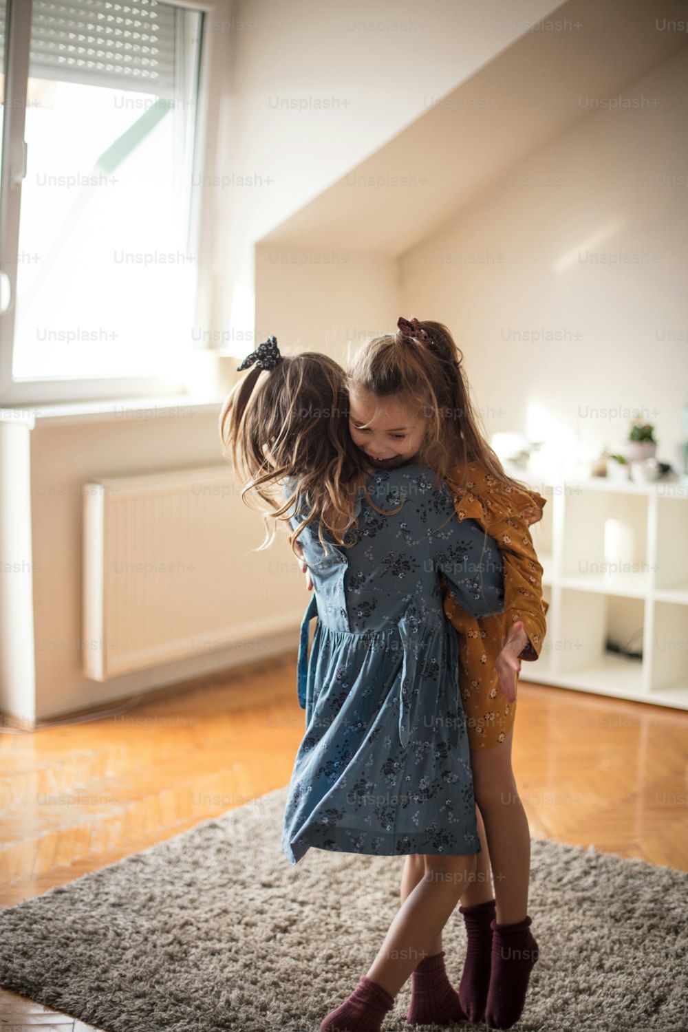 Common, lets have fun. Two little girls playing at home.
