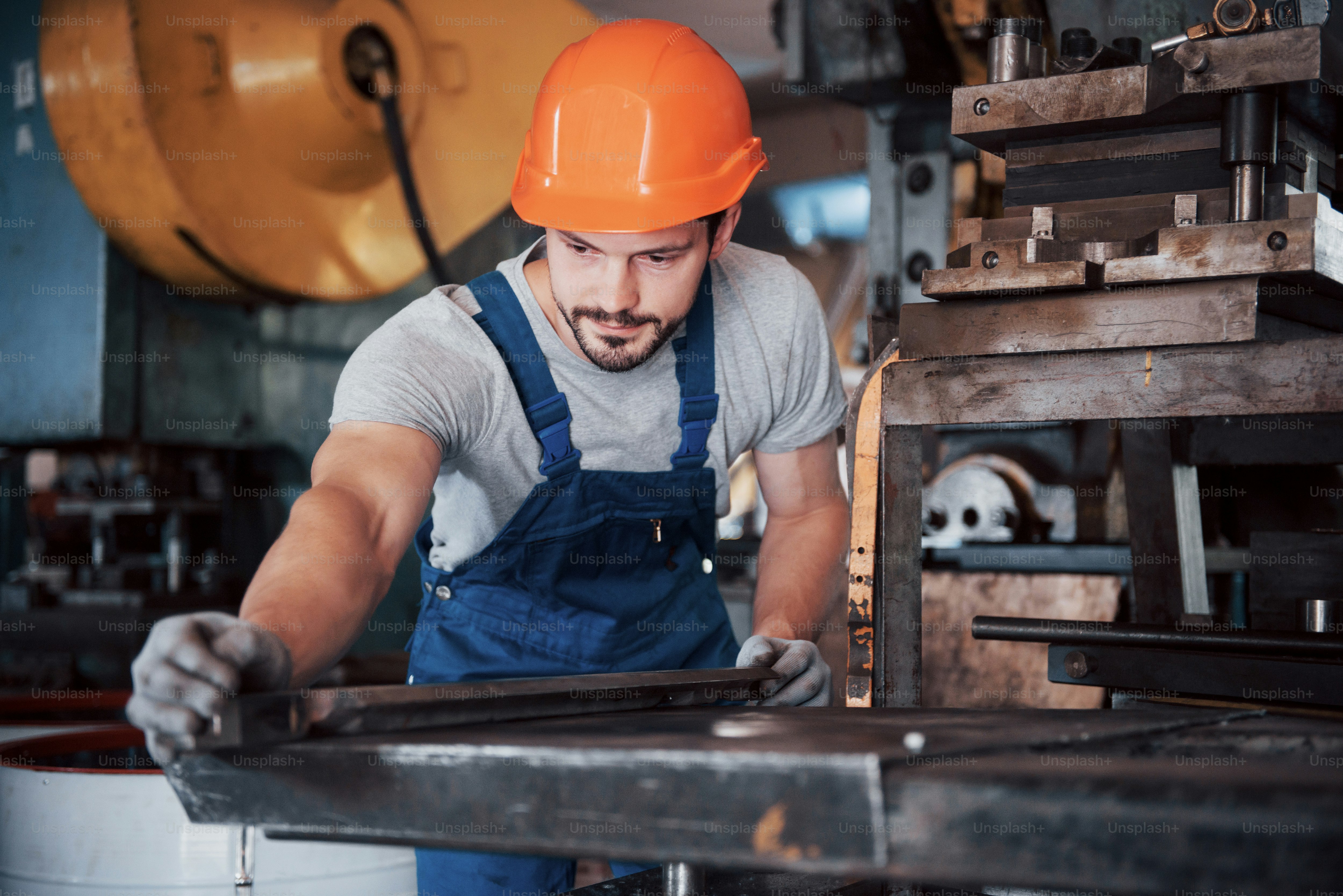 Portrait of a young worker in a hard hat at a large waste recycling ...