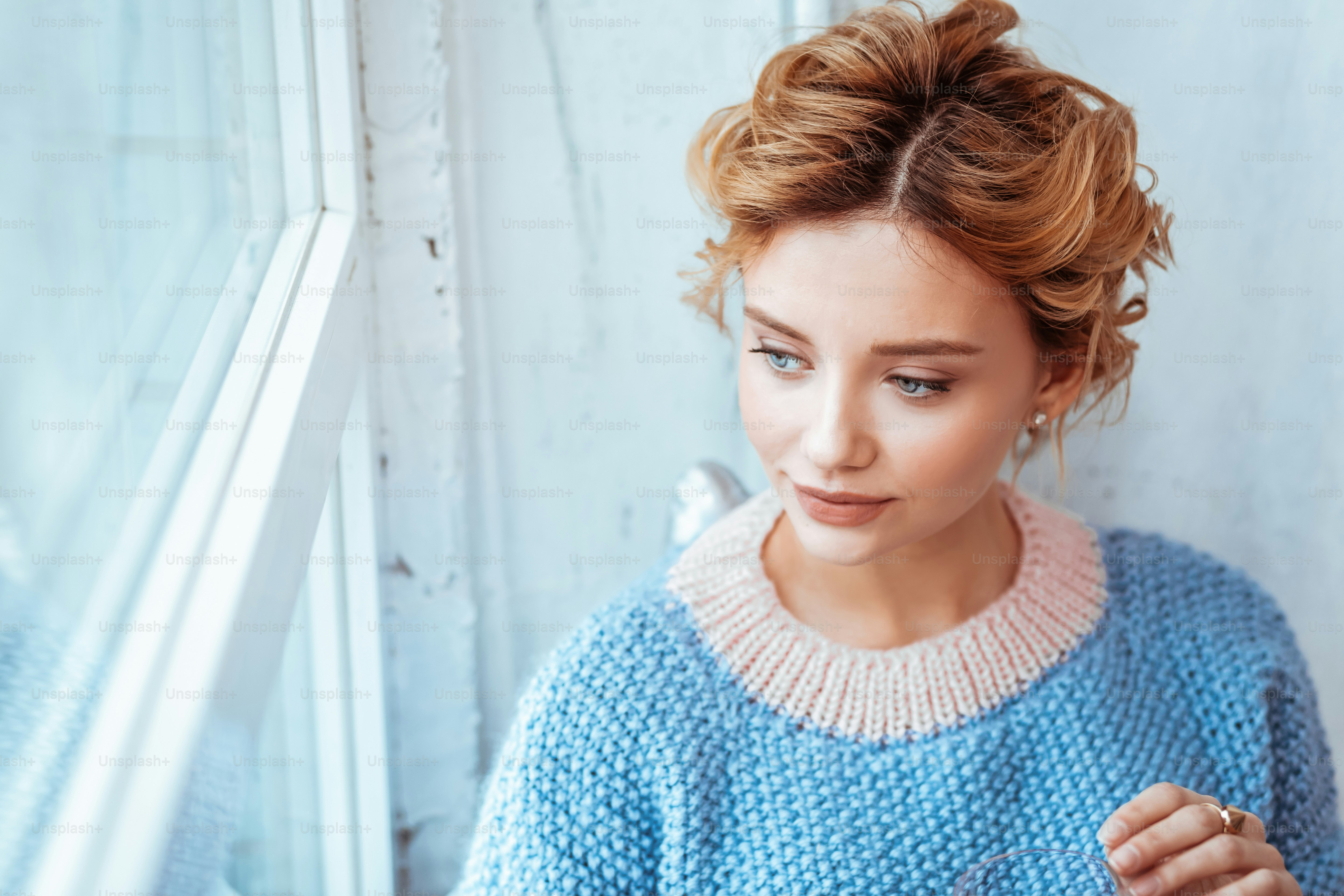Positive mood. Portrait of a pleasant delighted woman smiling while looking into the window