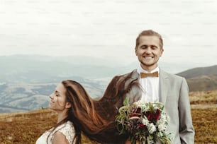 hermosa novia y elegante novio divirtiéndose, boda boho, ceremonia de lujo en las montañas