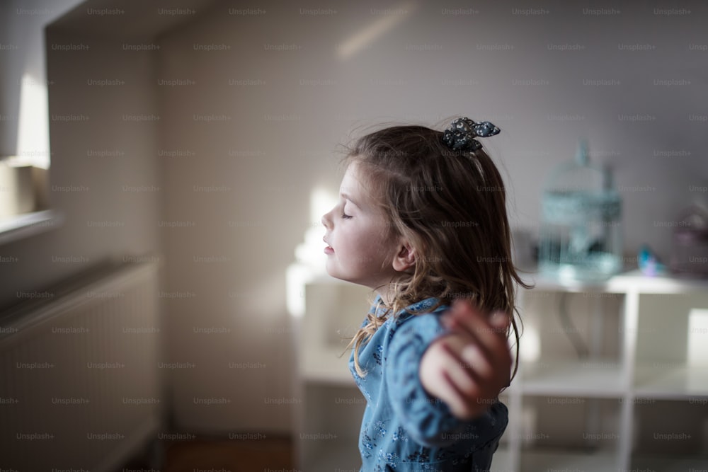 Meditate and be calm. Little girl at home.