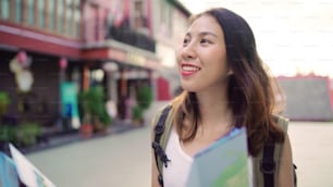 Alegre bela jovem mochileira asiática mulher direção e olhando no mapa de localização enquanto viaja em Chinatown em Pequim, China. Mochila de estilo de vida conceito de férias de viagem turística.