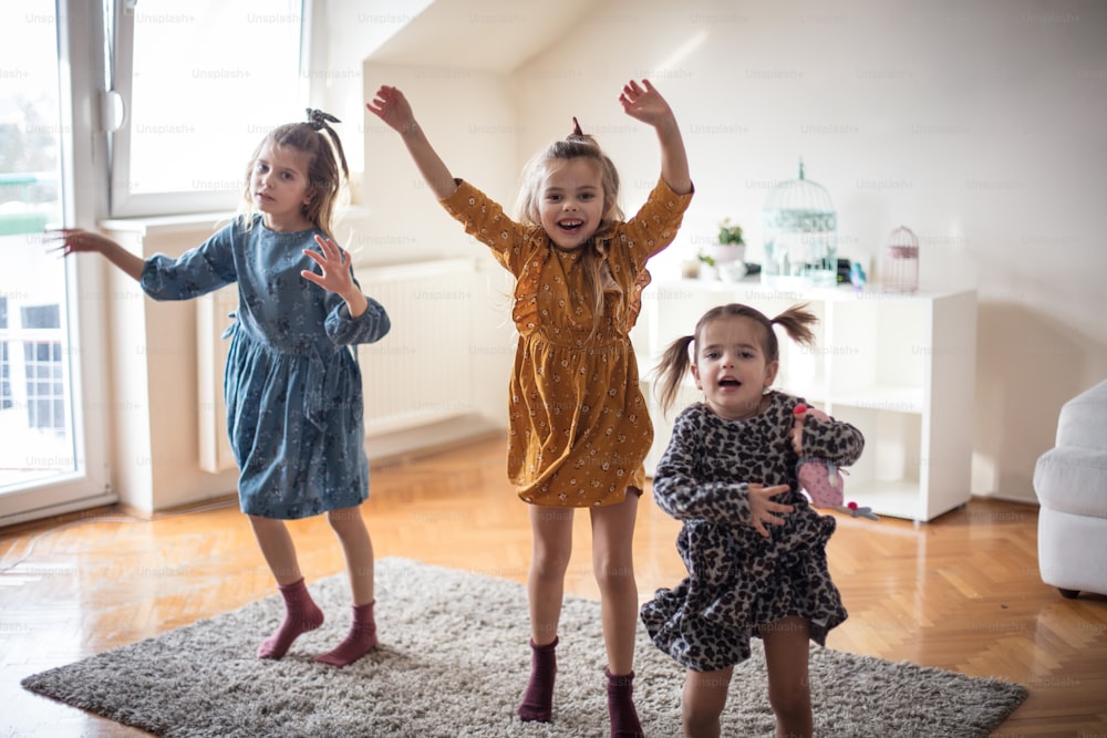 Gostamos de dançar. Três meninas se divertindo em casa.