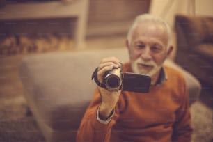 Hermosos recuerdos. Hombre mayor usando cámara. Concéntrese en la mano.