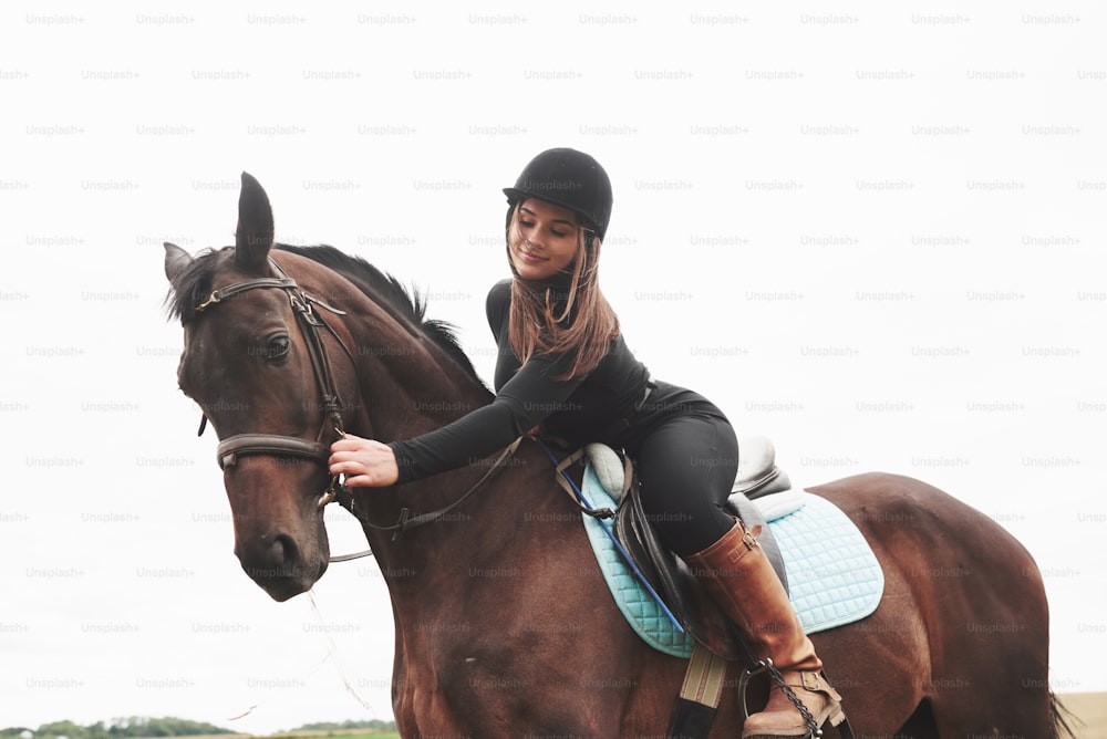 Young pretty girl - riding a horse, equestrian sport in spring time.