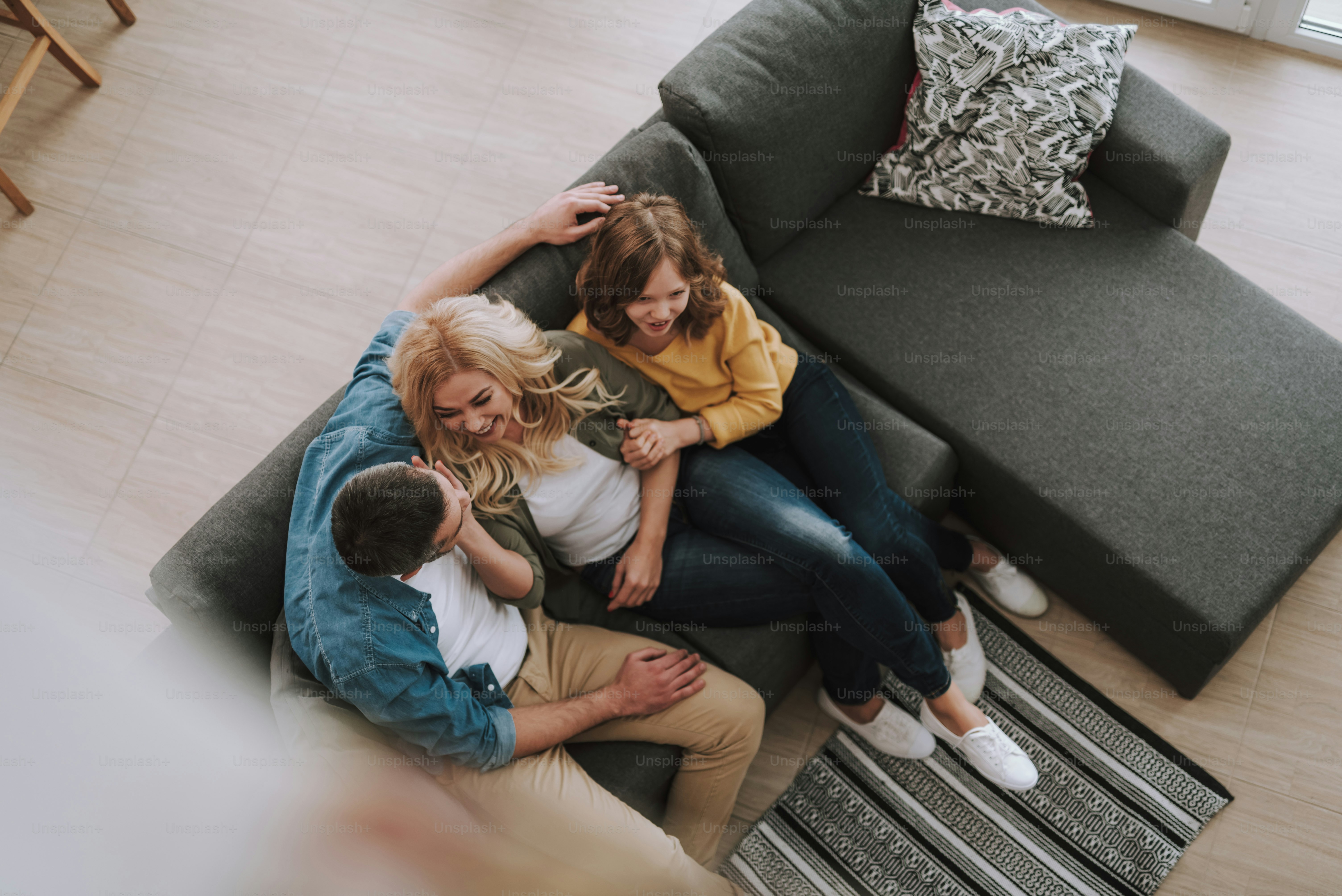 Vista superior retrato de una familia feliz que pasa tiempo juntos en casa. Hermosa esposa tocando la mejilla del esposo mientras linda niña sosteniendo su mano