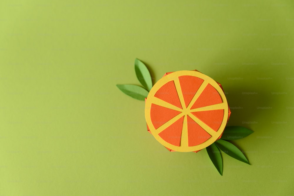 녹색 배경에 종이 오렌지 과일입니다. 공간을 복사합니다. 창의적이거나 예술적인 음식 개념