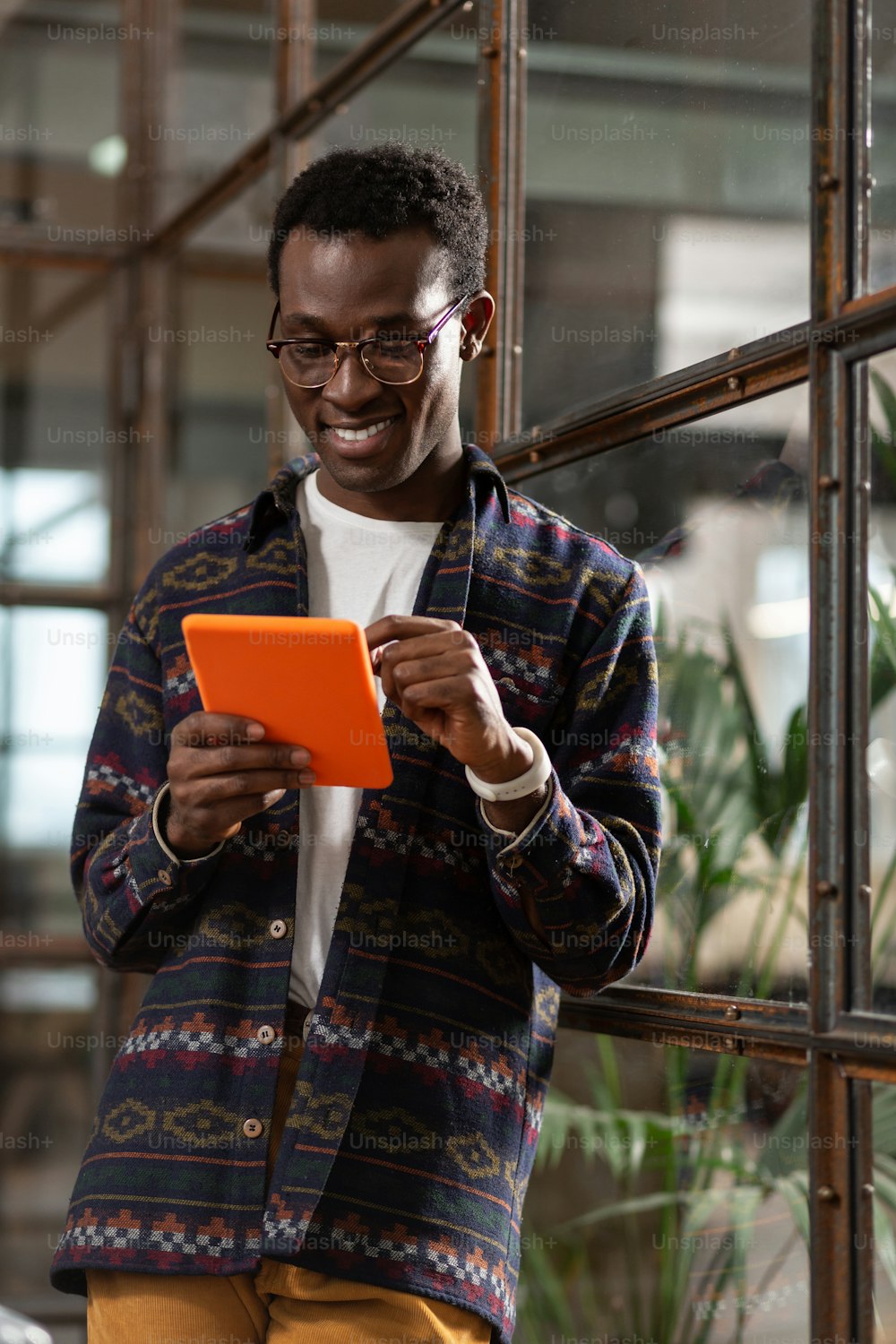 Gadget con estilo. Hombre sonriente usando una tableta en un estuche brillante