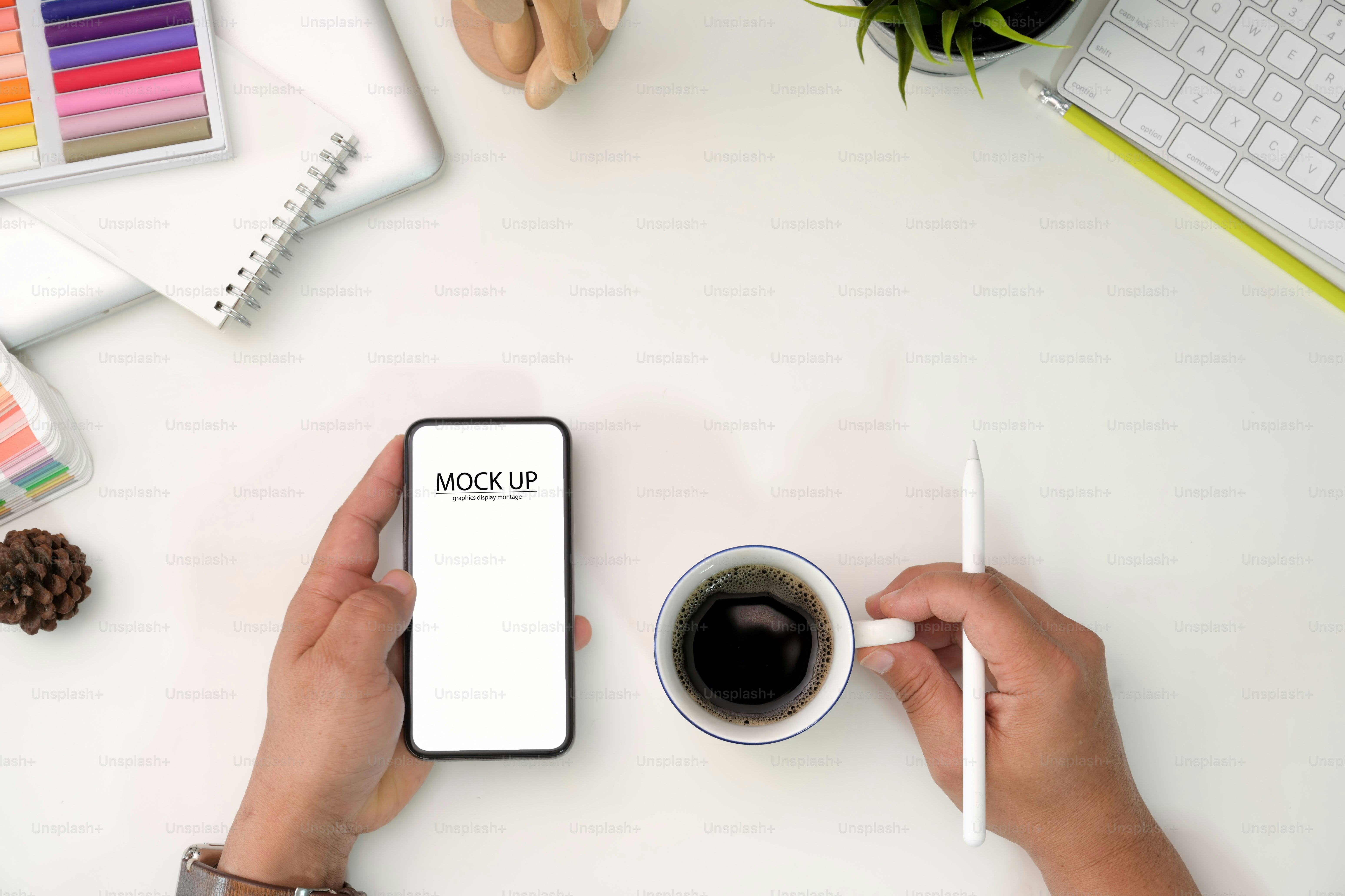 Designer creativo che tiene il telefono cellulare e la tazza di caffè sullo spazio di lavoro
